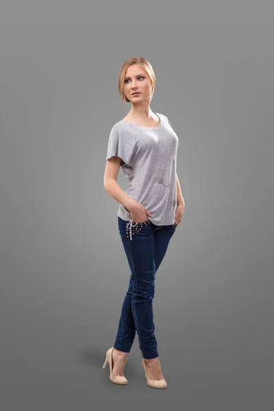 Ragazza in t-shirt bianca e jeans isolati su sfondo grigio — Foto Stock