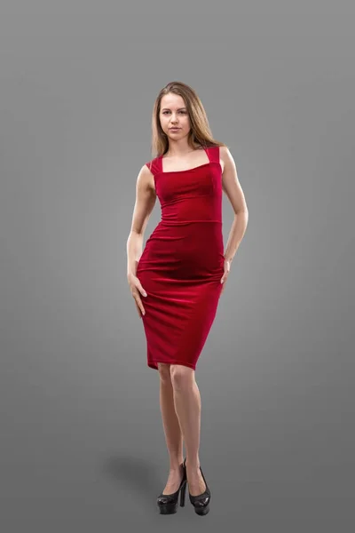 Hermosa mujer joven sexy en un vestido rojo sobre un fondo gris —  Fotos de Stock