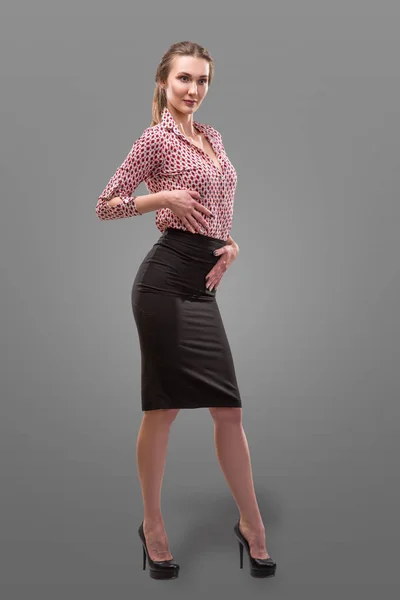 Retrato de una hermosa mujer de negocios con una camisa roja y falda negra con base de piel de maquillaje sobre fondo gris —  Fotos de Stock