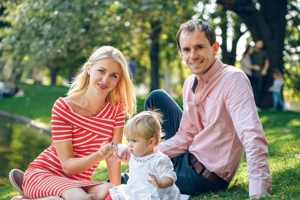 Happy mother, father and daughter in the park