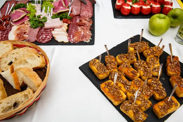 cheese sticks. Food tray with delicious salami, pieces of sliced ham, sausage, salad. Bread. Tomatoes stuffed with cheese and garlic - Meat platter with selection