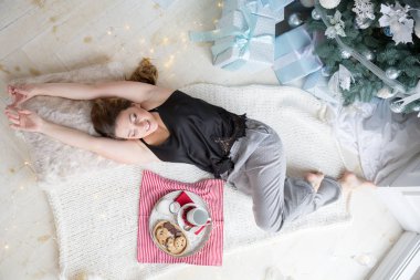 Yerde yatarken ve gülümseyen güzel kadın. Noel kavramı. Yeni yıl arifesi güneşli sabah