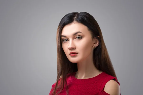 Mujer morena bonita en vestido rojo sobre fondo gris . —  Fotos de Stock