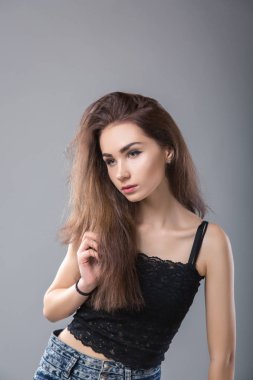 Güzel seksi makyaj model gri arka plan üzerinde siyah gömlek poz.