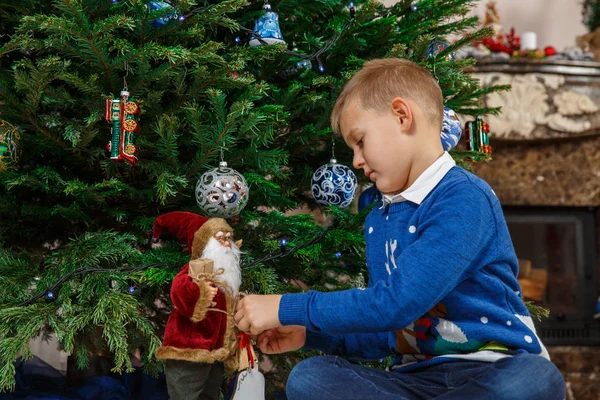 Mały chłopiec dekorowanie choinki. Boże Narodzenie szczęśliwe dziecko z lalka Santa. Ferie zimowe i wakacje. Christmasmas party celebration. — Zdjęcie stockowe