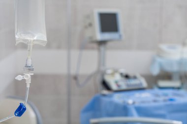 Damlalık içinde bir ven yakın çekim. tıbbi ofis odak içinde arka planda bir LCD ekran. Mavi arka plan. Vücut temizliği kavramı