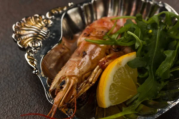 Una gran cabeza de camarón tigre frito con limón y rukkola en el plato antiguo —  Fotos de Stock
