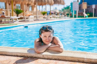 Kadın Yüzme Havuzu su rahatlatıcı. Yaz güneş sıcak yaz gününde havuzda zevk kız