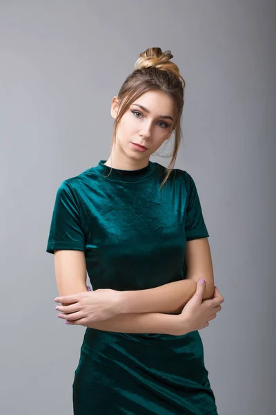 Porträtt av vacker kvinna med smink, frisyr och naturliga fräknar på hennes ansikte i grön klänning poserar och titta på kameran på grå bakgrund. — Stockfoto