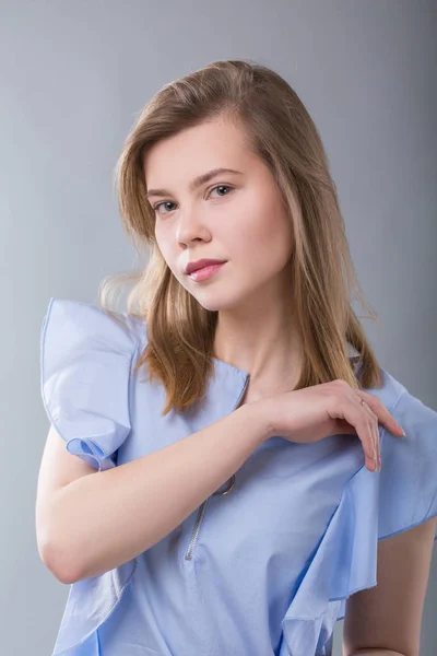 Studio colpo di giovane bella donna che indossa abito blu sullo sfondo grigio — Foto Stock