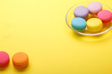 Sarı arka plan üzerinde renkli kurabiye. Tatlı macarons. metniniz için kopya alanı