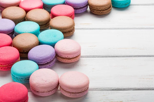 Fermer macarons colorés dessert sur une table en bois. Doux fond de macarons français . — Photo