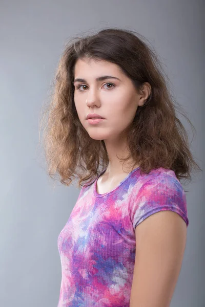 A szürke háttér egy hétköznapi fiatal nő portréja — Stock Fotó