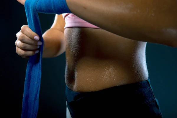 Femme emballe les mains avec des enveloppements de boxe bleue. Main et poing forts, prêts pour le combat et l'exercice actif. Image de lavage mat — Photo