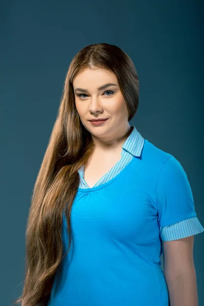 Attraente donna plus-size che indossa camicetta blu in ambiente studio. Ragazza con i capelli lunghi su sfondo blu — Foto Stock