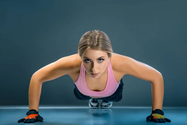 Ung sportig kvinna göra armhävningar, fitness tjej tränar plankan motion på händer för kropp skulptera, four-limbed personal yoga pose på studio, motiverade flicka åtnjuter pilates träning på golvet — Stockfoto