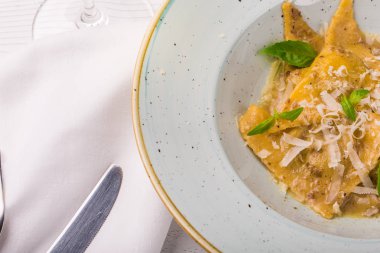 İtalyan Mantısı tortellini beyaz tabakta fesleğen ve parmesan peyniri ile