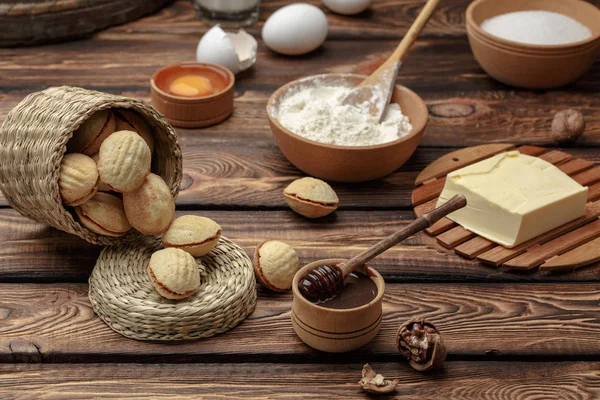 Zelfgemaakte koekjes vormige noten met gekookte gecondenseerde melk op houten tafel — Stockfoto