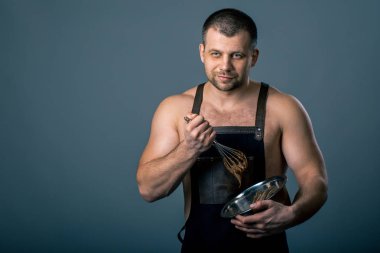 Şef cheesecakes koyu arka plan üzerinde yapmak için el ile bir kase krem çikolata kamçı