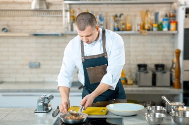 Şef holding kızartma tavası. Şef profesyonel mutfak çanak tavada karıştırarak. Avrupa gıda hazırlanması.