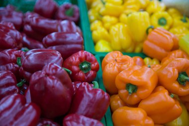Kırmızı, turuncu ve sarı biber. Üstünde belgili tanımlık sayaç, Pazar çiftçi bölümünde kutularındaki kırmızı biber.