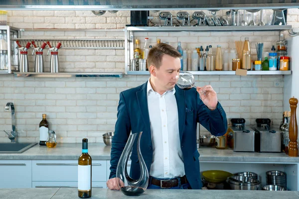 Especialista em vinho avaliando sabor. Homem atraente agitando um copo para fazer vinho rodopiando e cheirando-o para sentir cada nota de buquê . — Fotografia de Stock
