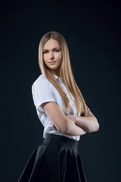 Bella ragazza adolescente sorridente in gonna nera e bianco studio camicia ritratto. Felice studente o studentessa con i capelli lunghi guardando la fotocamera su sfondo nero . — Foto Stock