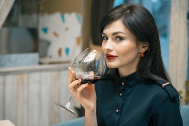 Genç ve güzel kadın kırmızı şarap tatma. kadın şarap burnunu çekmek