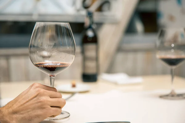 Homem segurando copo de vinho no restaurante — Fotografia de Stock
