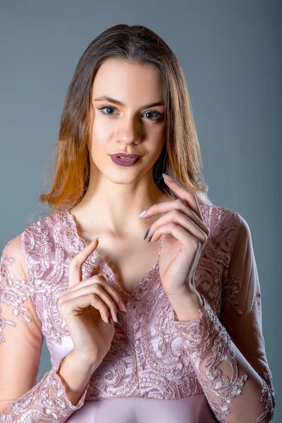 Mode Porträtt av modell kvinna på en blå grå bakgrund i lacy rosa klänning — Stockfoto