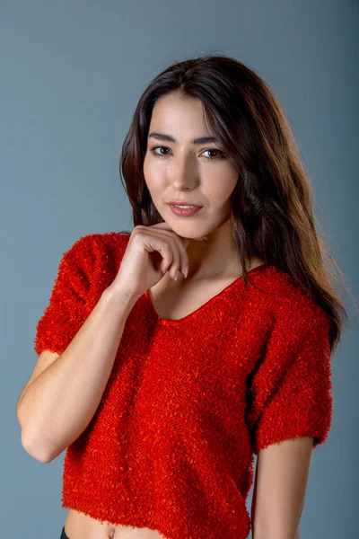 Záběr rádi pretty woman s příjemně okouzlující úsměv, oblečený v červený svetr, vyjadřuje pozitivní emoce, šedé pozadí. Výrazy obličeje koncept. — Stock fotografie