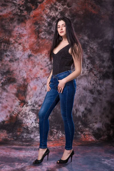 Bella donna curvy Posa in camicia nera e jeans su sfondo multicolore. Test del modello plus size — Foto Stock