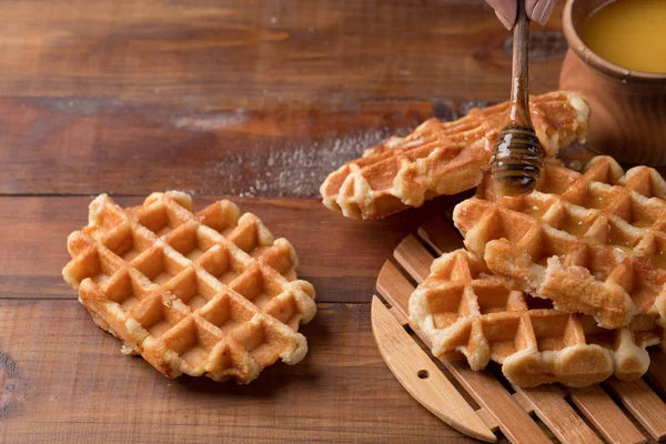 Honung hälla på en färska våfflor. Frukost med våfflor — Stockfoto