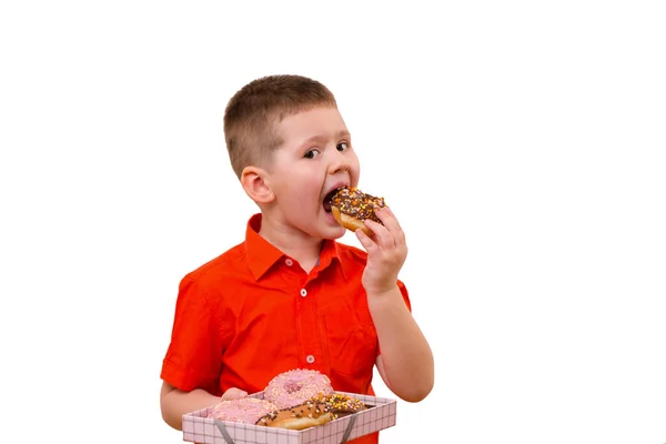 Adorável menino comer donut com chocolate — Fotografia de Stock