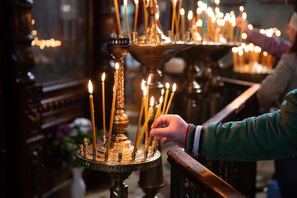 Człowiek ręcznie oświetlenie świece w kościele — Zdjęcie stockowe