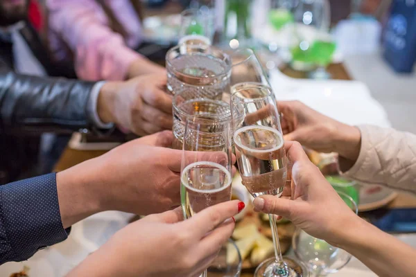 Clinking copos de champanhe em mãos no fundo da mesa servida — Fotografia de Stock