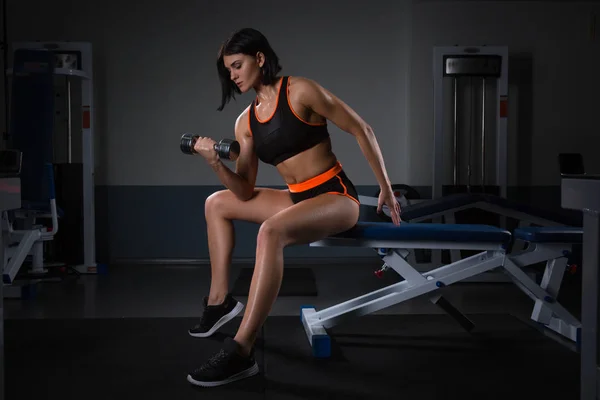 Lady Hand lyft upp hantel ena handen på Gym för kroppsbyggare. i sittande hantel koncentration Curls åtgärd. Halthy koncept. — Stockfoto