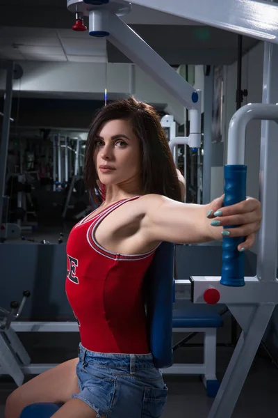 Αθλητικά γυναίκα κάνει ασκήσεις στις συσκευές κατάρτιση εξουσία στο γυμναστήριο. Στο Στόουκ. Το νεαρό κορίτσι που κάνει άσκηση στη συσκευή κατάρτισης. Έννοια Halthy — Φωτογραφία Αρχείου