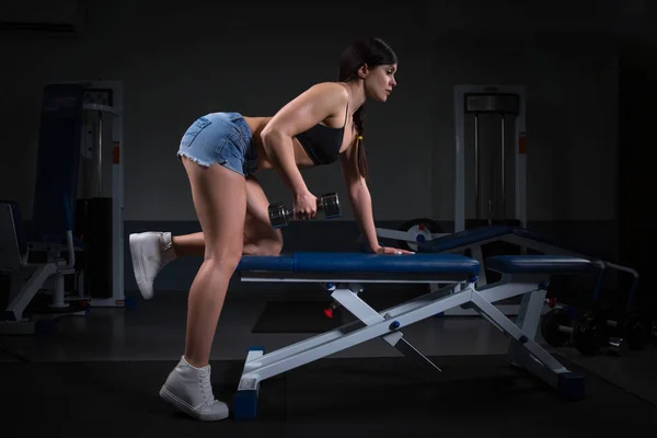 Mujer ejercitando fila de pesas en el gimnasio. Aptitud. concepto halthy —  Fotos de Stock