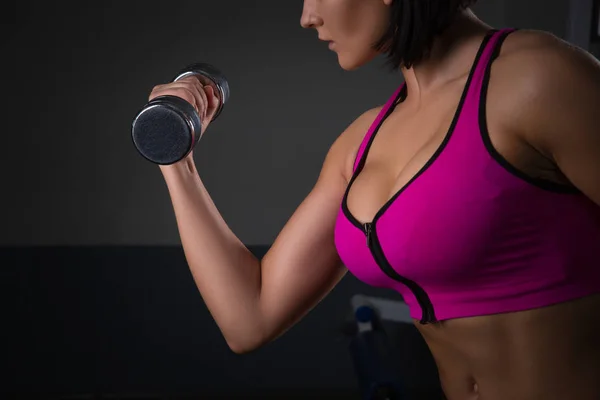 Atletik genç kadının siyah stüdyo arka plan üzerinde dumbbells ile bir fitness egzersiz yapması. Halthy kavramı — Stok fotoğraf