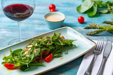 Taze salata domates ve karışık yeşillik. roka, mesclun, mache ahşap arka plan üzerinde. Sağlıklı gıda.