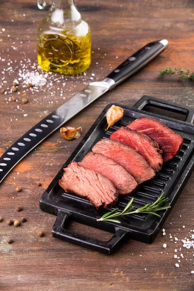 Grilovaný hovězí steak se solí, česnekem a rozmarýnem na broušené desce. — Stock fotografie