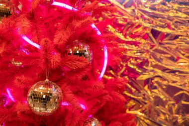 Bronz kahverengi kaburgalı disko topu oyuncağı metalden ya da plastikten yapılmış Noel ağacının üzerine çelenk ve bulanık arka planda kar, yakın plan Bokeh, kış