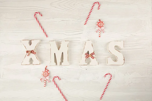 Tytuł Boże Narodzenie z cukierkami na drewnianym białym niebieskim tle. Świąteczna kartka, święta — Zdjęcie stockowe