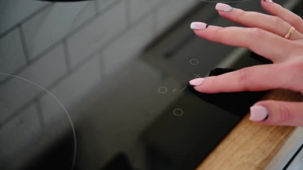 Un primo piano di una mano femminile include una stufa elettrica. Tecnologia moderna. Pannello tattile di fornello elettrico — Video Stock