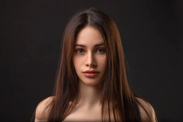 Siyah arka planda çıplak makyajlı esmer bir kadının moda fotoğrafı.