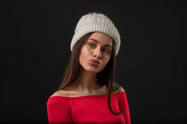 美丽的年轻欧洲女人的画像 嘴唇圆圆的 戴着温暖的冬帽 在黑色的背景上摆出姿势 寒冷天气的概念 — 图库照片