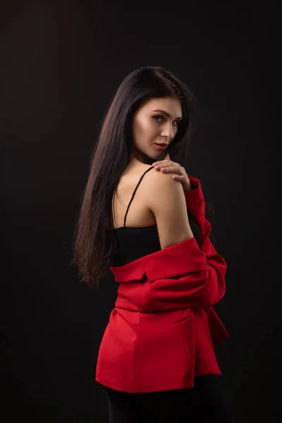 Siyah Arka Planda Kırmızı Takım Elbiseli Uzun Saçlı Şık Esmer — Stok fotoğraf