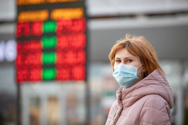 woman wearing protective mask against currency exchange. infectious diseases and as protection against pollution and the flu. clipart