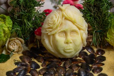 Oyma. Dekorasyon için kesilmiş çiğ sebzeler. İstiridyenin üzerindeki turptan kesilmiş yüz. kompozisyon hazırlama